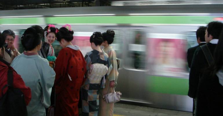 Kimono-clad women waiting for a train.