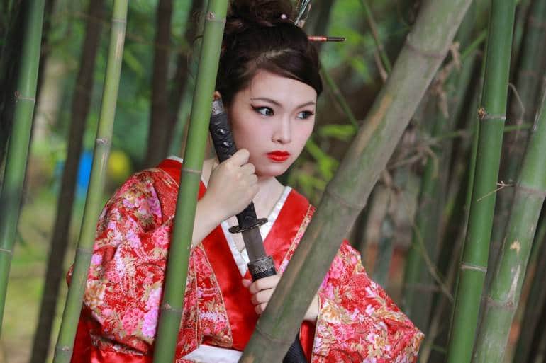 Once you've got your cheapo kimono, all you need is a sword and bit of bamboo to complete your Japan experience. Woman in bamboo forestpic via Shutterstock.