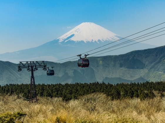 The Hakone Ropeway over a plain of grasses and Mt Fuji in the background