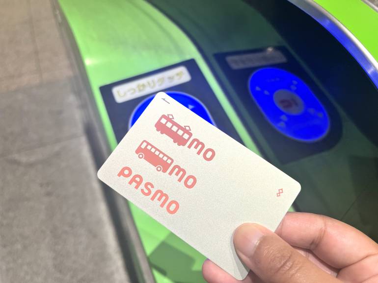 Pasmo IC card held up at a station ticket gate reader