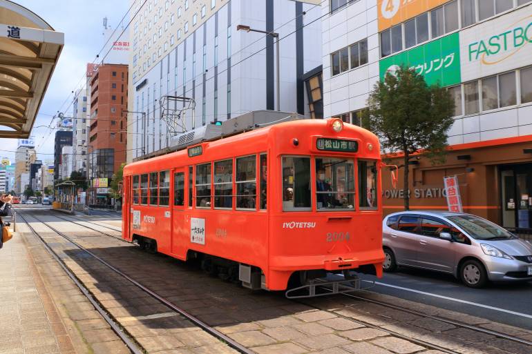A bright orange tram in Matsuyama, Shikoku