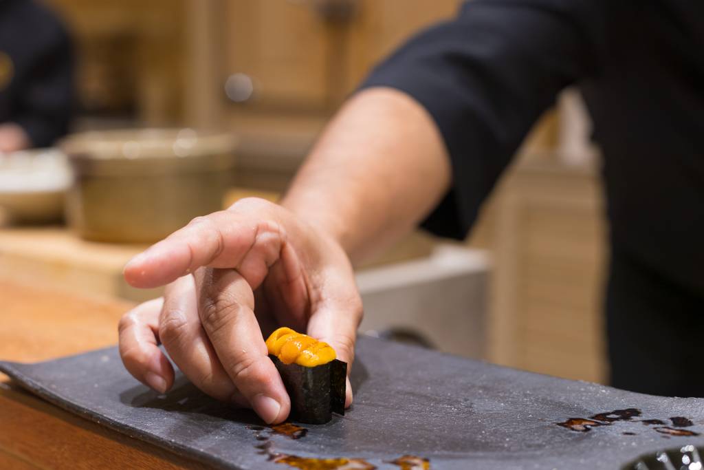 Close up of Japanese chef preparing uni sushi in japanese style.Omakase couse.
