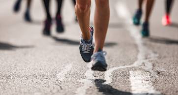 Unrecognizable marathon runner having a race on the road.