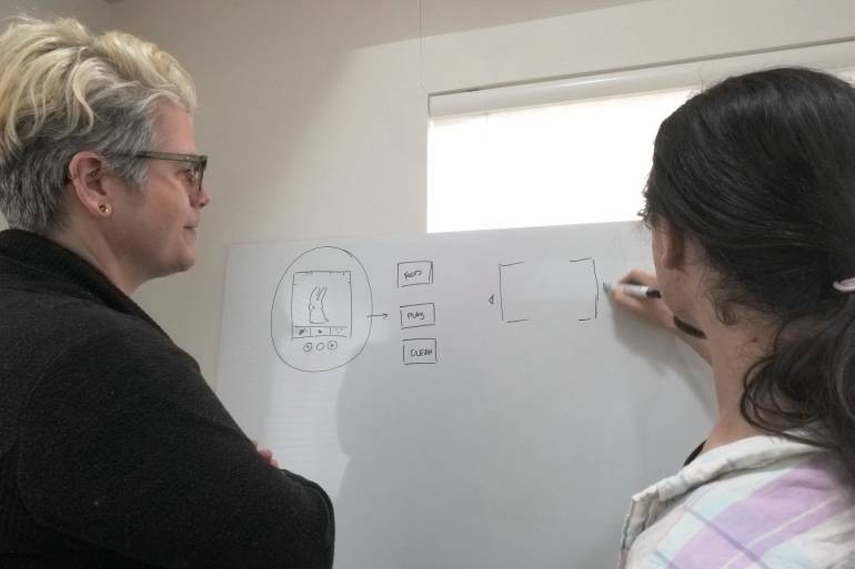 CJ and Matt whiteboard a game idea.