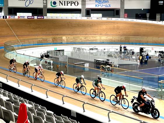Keirin racers chase the pacer around the boards at the velodrome