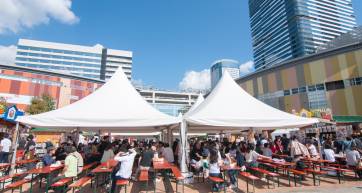 Crowds at long tables under white beer tents at Oktoberfest, Urban Dock LaLaport Toyosu