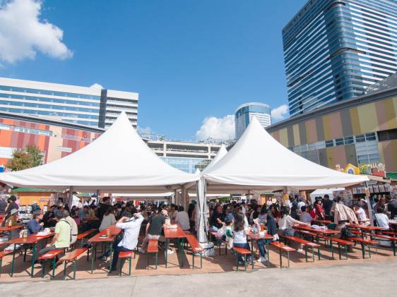 Crowds at long tables under white beer tents at Oktoberfest, Urban Dock LaLaport Toyosu