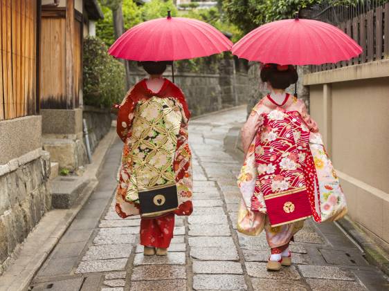 Young Japanese women maiko apprentice geisha walking in the historic Gion area of Kyoto, Japan