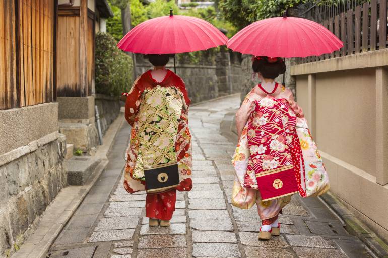Young Japanese women maiko apprentice geisha walking in the historic Gion area of Kyoto, Japan