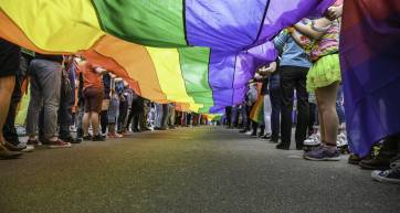Under a LGBT Pride Flag,