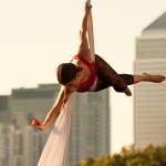 Aerial performer in front of London buildings