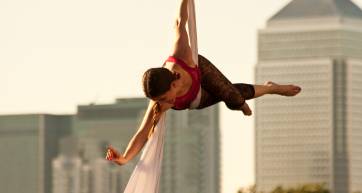 Aerial performer in front of London buildings