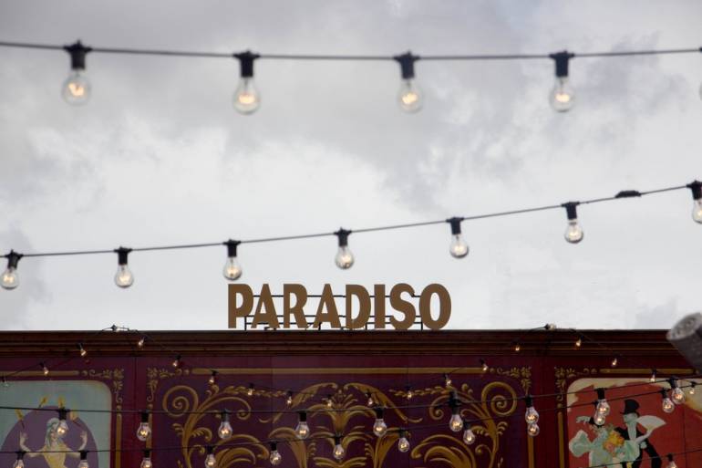 A sign reading Paradiso and some string lights