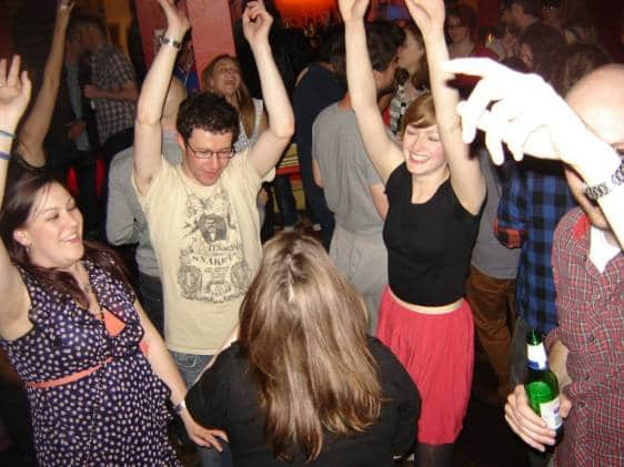 A group of people dancing with their hands in the air